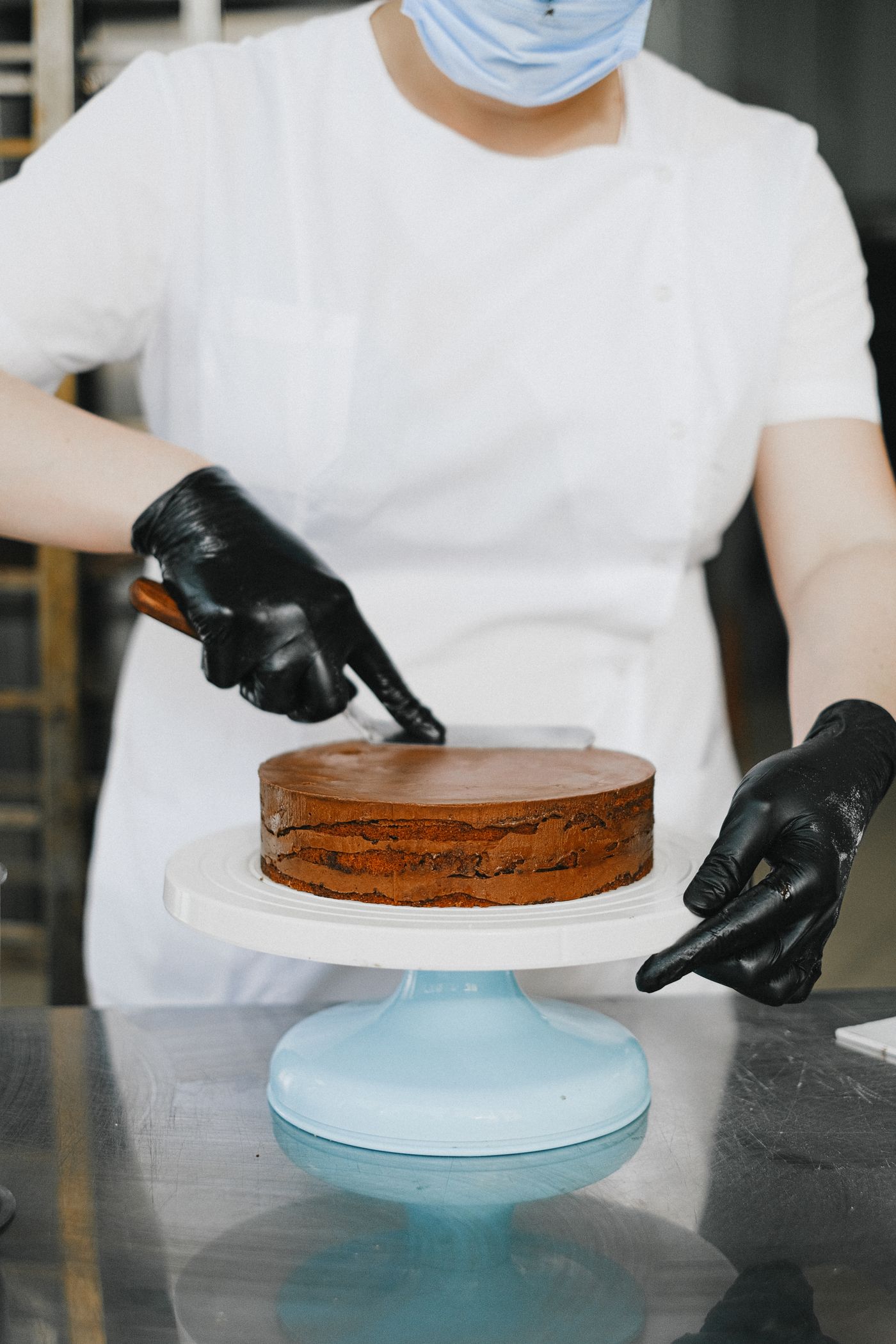 Konditorin verziert eine Torte mit dem Spritzbeutel